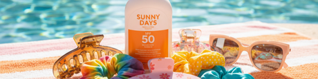 Sunny pool day essentials: SPF 50 sunscreen, stylish sunglasses, and colorful hair accessories on a striped towel.