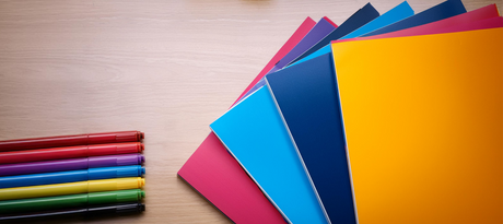 Vibrant posterboard sheets in various colors with matching markers, ideal for business presentations.