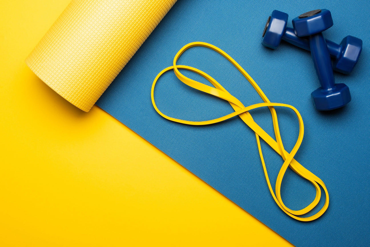 Yoga collection with blue mat, yellow resistance band, and dumbbells for fitness businesses.